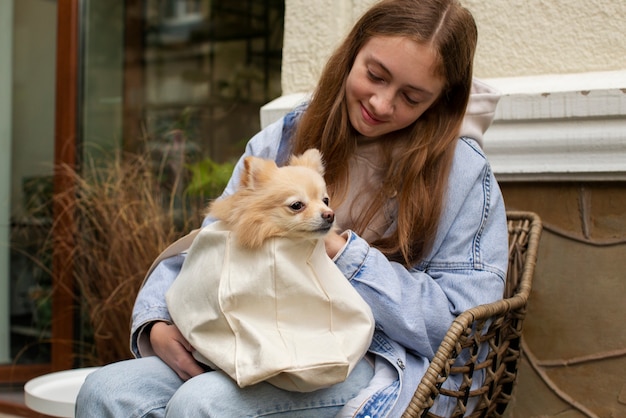 犬のミディアムショットでバッグを保持している女の子