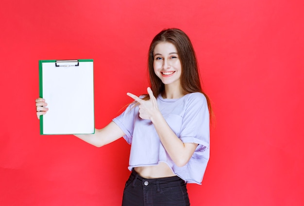 Girl holding a blank reporting sheet. 