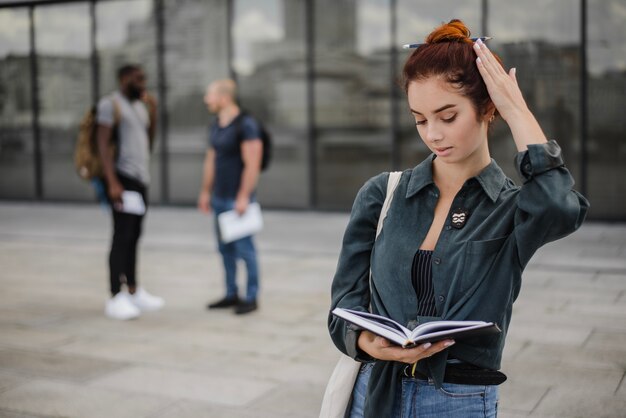 Girl holding book reading standing