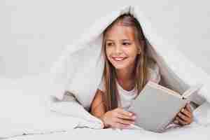 Free photo girl holding a book while looking away