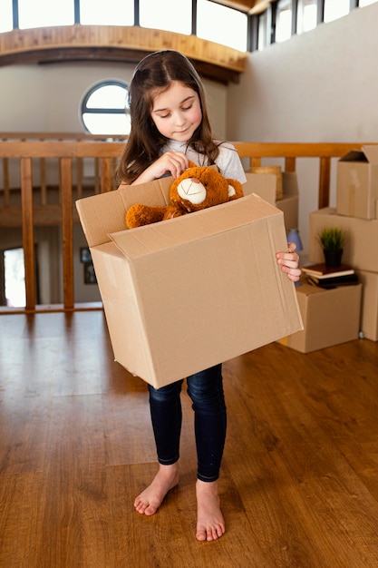 Girl holding box with toy full shot