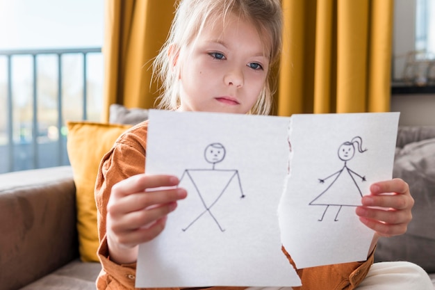 Girl holding broken drawing