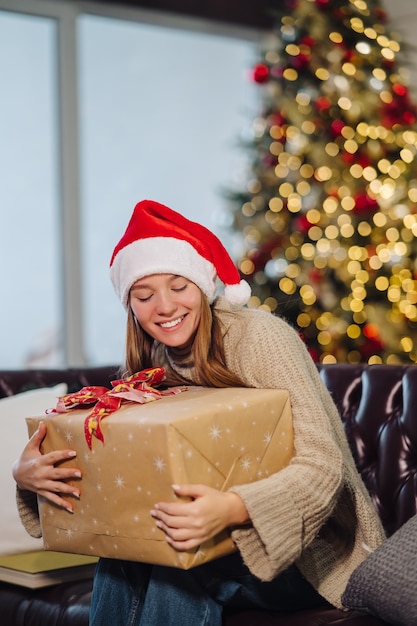 Girl holding a Christmas present on New Years Eve. Girl looking at the camera