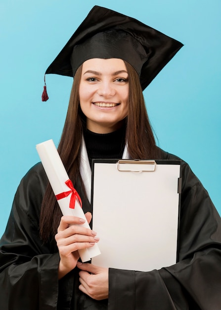 Girl holding clipboard and diploma