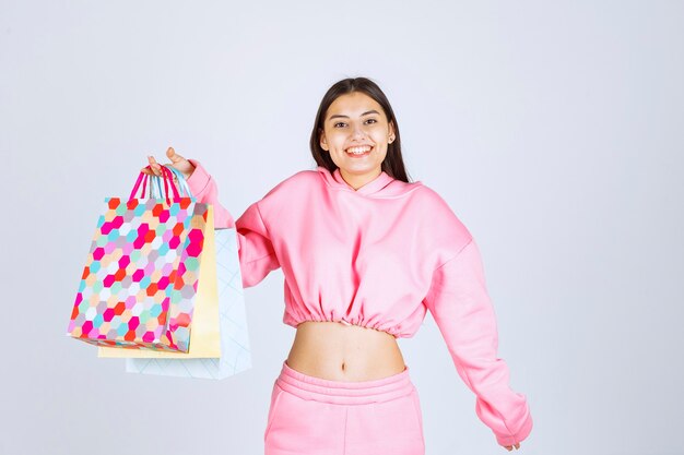 Girl holding colorful shopping bags and looks excited. 