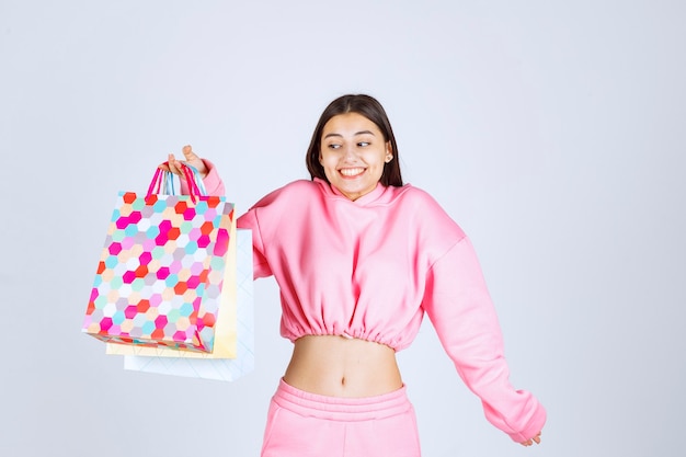 Girl holding colorful shopping bags and looks excited. 