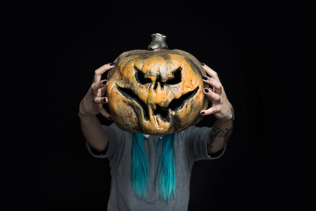 Free photo girl holding creepy pumpkin