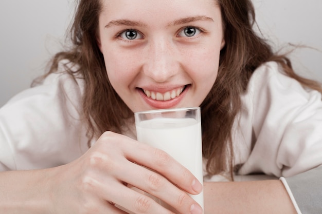 Foto gratuita ragazza che tiene giù un bicchiere di latte