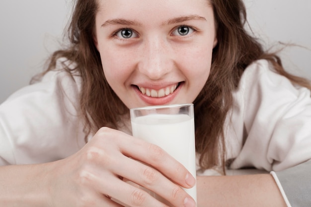 Девушка держит стакан молока