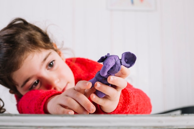 Free photo girl holding elephant made of clay