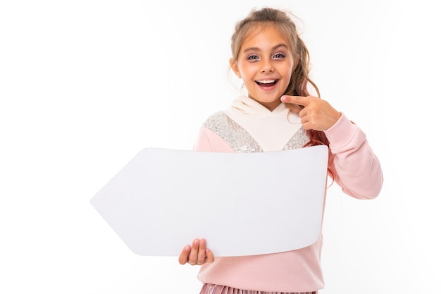 Girl holding an empty arrow template made of paper with copy space on a white studio background.