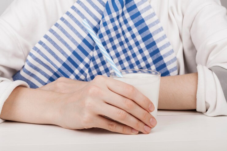 Free Photo girl holding a glass of milk close-up