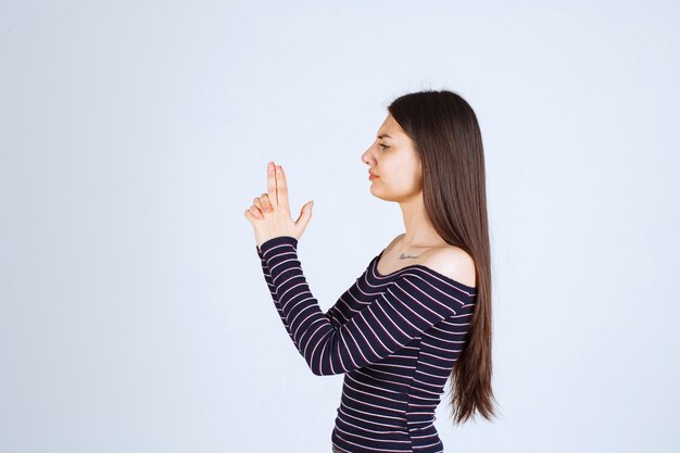 Girl holding hand gun sign. 