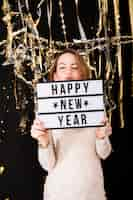 Free photo girl holding happy new year sign