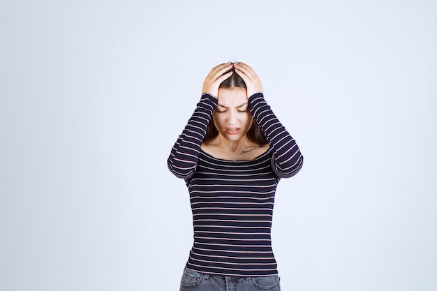 Girl holding her head as she is tired or has headache. 