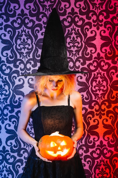 Girl holding lighted pumpkin