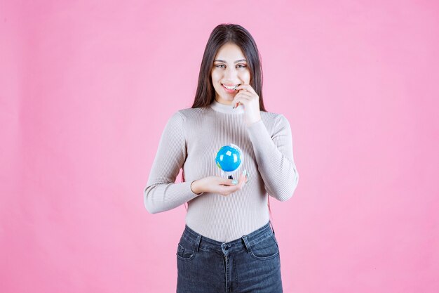 Girl holding a mini globe and smiling