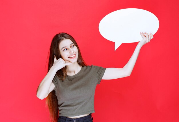 Girl holding an ovale idea board and showing her ears. 