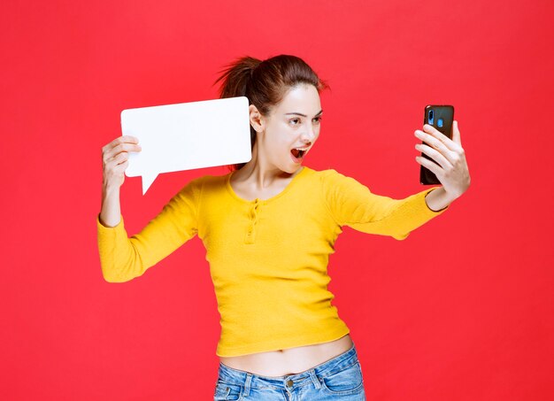 Girl holding a rectangle info board and making a video call.