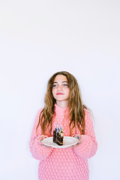 Girl holding slice of chocolate cake