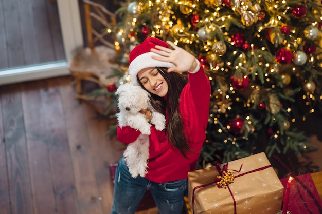 Girl holding a small dog in her arms on new year's eve