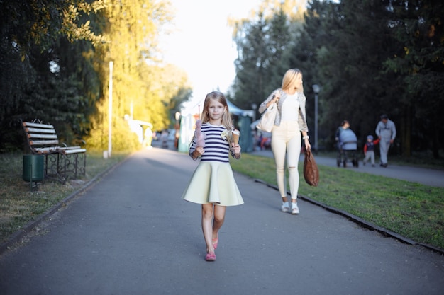 Girl holding a stick with sugar cloud and an ice cream cone