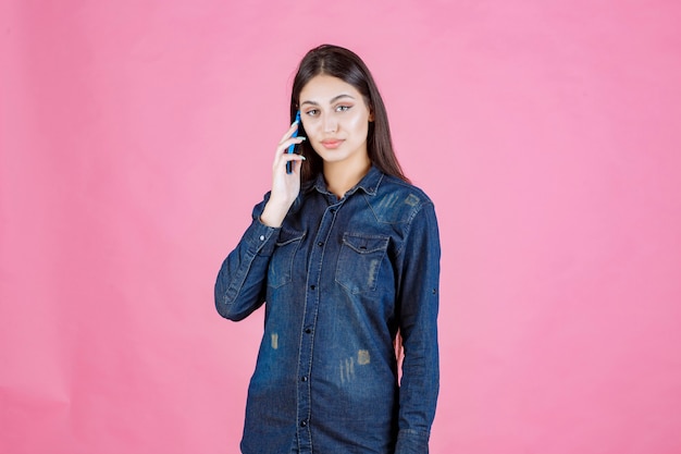 Girl holding talking to her blue smartphone