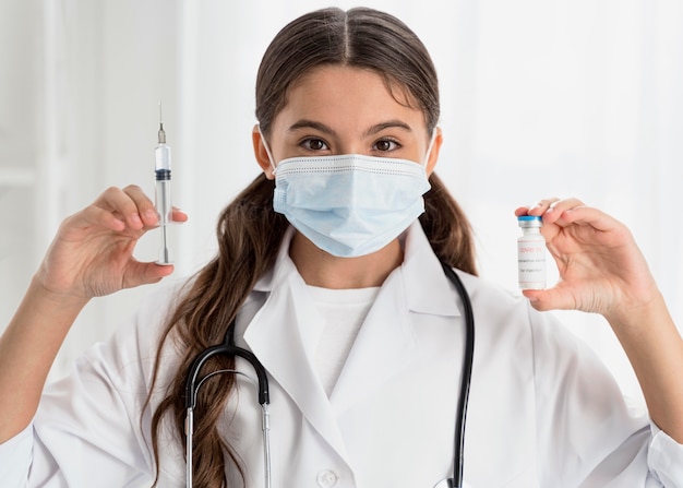 Girl holding a vaccine recipient and a syringe