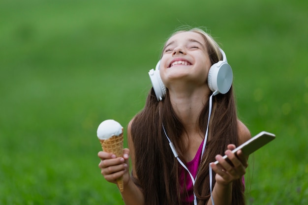 Девушка держит ванильное мороженое и телефон