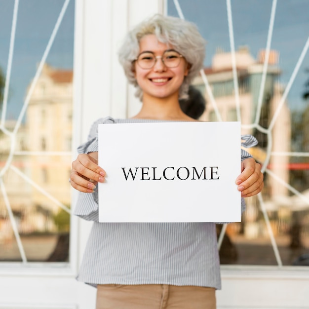 Free photo girl holding a welcome sign