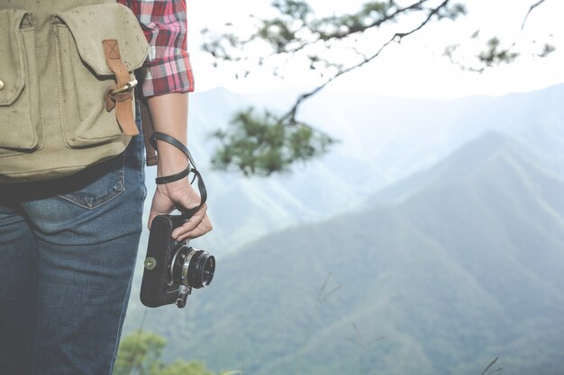 少女はカメラを持って、熱帯林でハイキングをし、森のバックパック、冒険、旅行、観光、登山ハイキングをします。