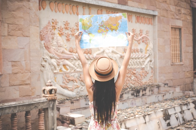 Девушка держит туристическую карту в старом городе.