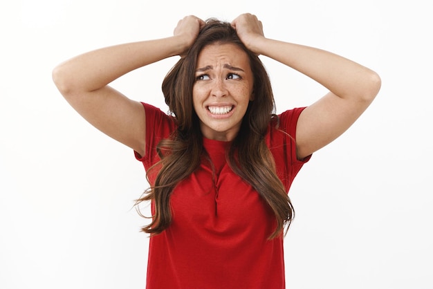 Free photo girl in huge trouble panic shocked upset brunette woman pull hair from head grimacing in sorrow and disappointment frowning crying from troublesome problematic situation white background