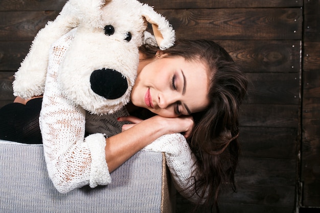 Girl hugging a cute dog toy.