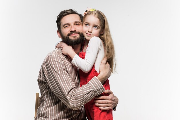 Girl hugging her father  over a white 