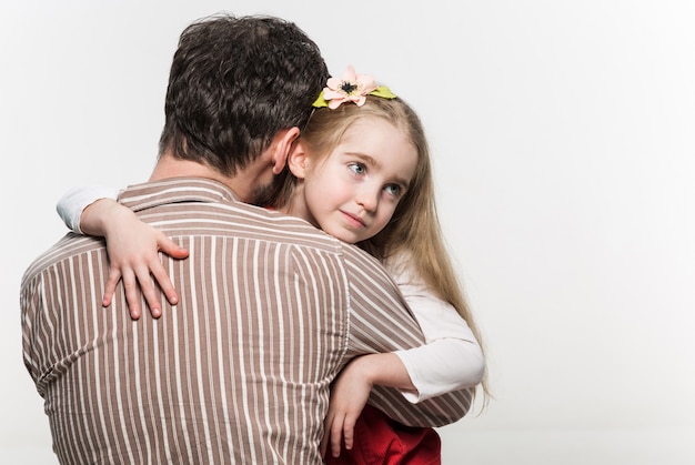 Foto gratuita ragazza che abbraccia suo padre sopra un bianco