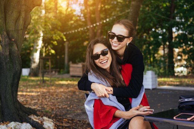 彼女の友人を抱き締める少女。肖像画公園の2つのガールフレンド。