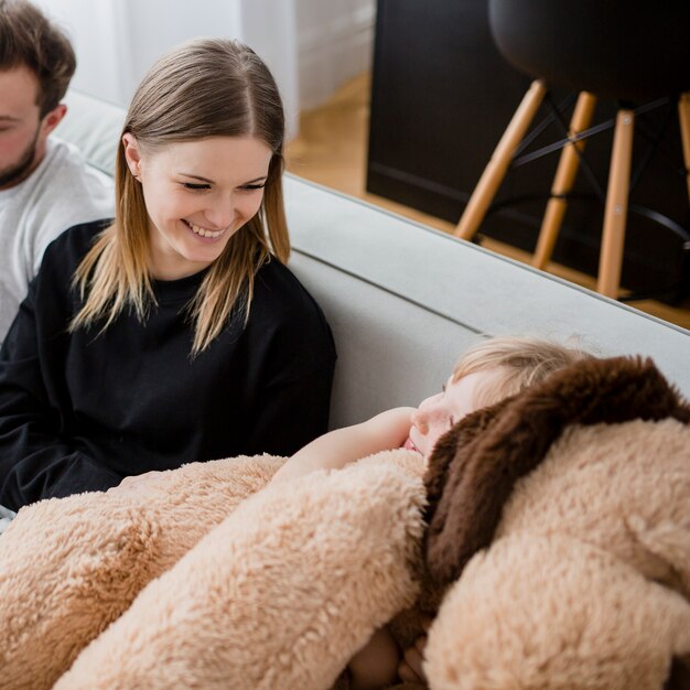 girl hugging toy near parents