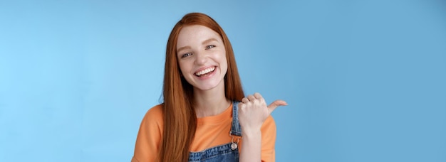 Girl introducing her friend pointing thumb left smiling laughing joyfully proudly telling pros cool 