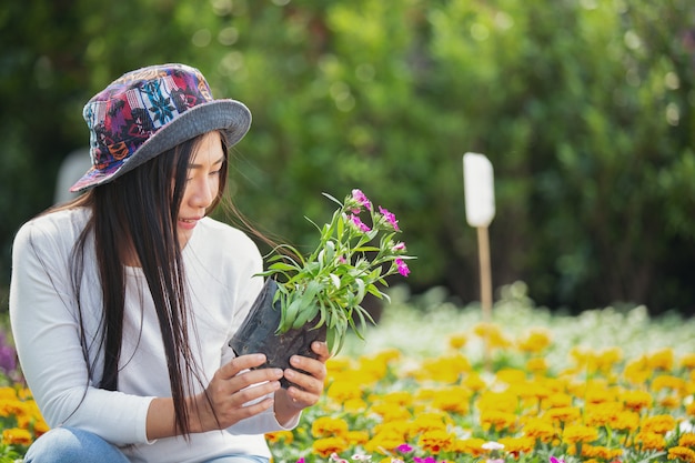 The girl is admiring the flowers in the garden.