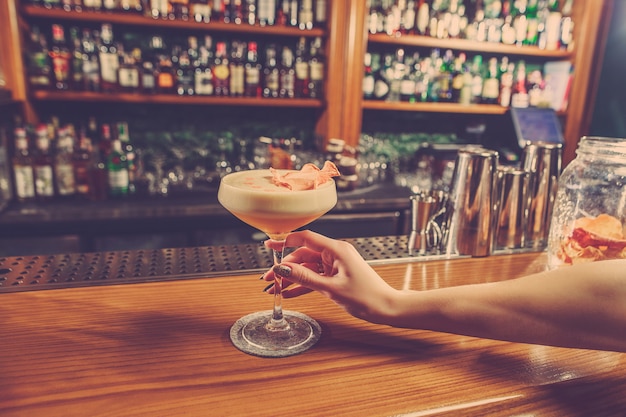 The girl is holding in his hand a glass of alcoholic beverage