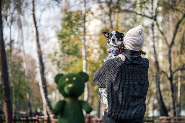 A girl is holding a mongrel dog in her arms. Caring for animals.