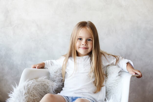 The girl is sitting in the living room