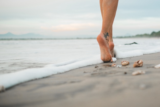 the girl is walking along the beach