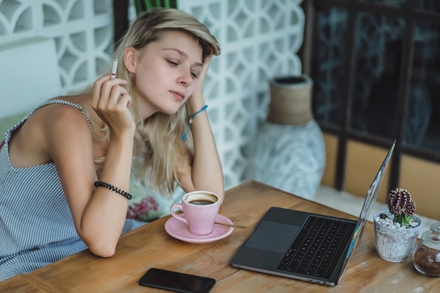 girl is working in a cafe. concept of freelancing, coffee and laptop.