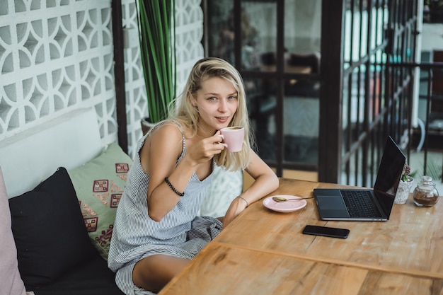 girl is working in a cafe. concept of freelancing, coffee and laptop.