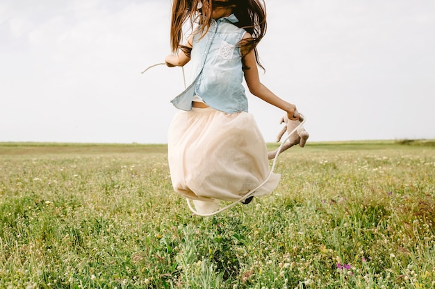 Девушка прыгает в поле
