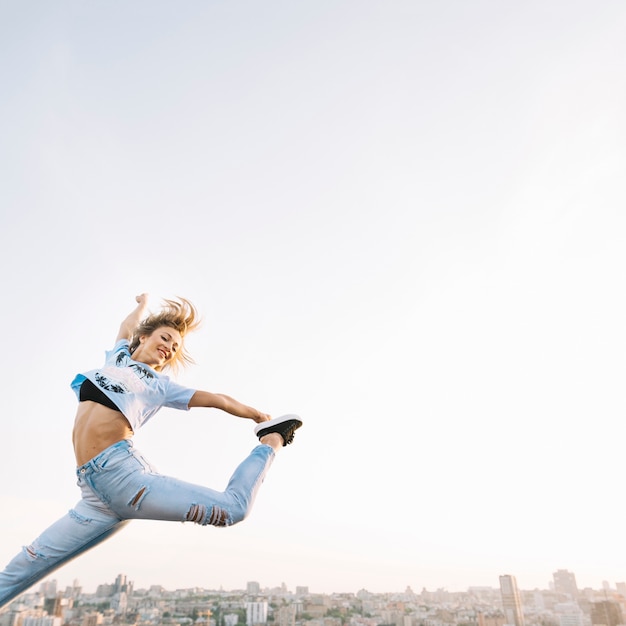 Free photo girl jumping on rooftop