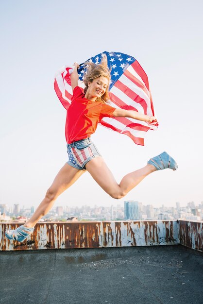 Girl jumping with american flag