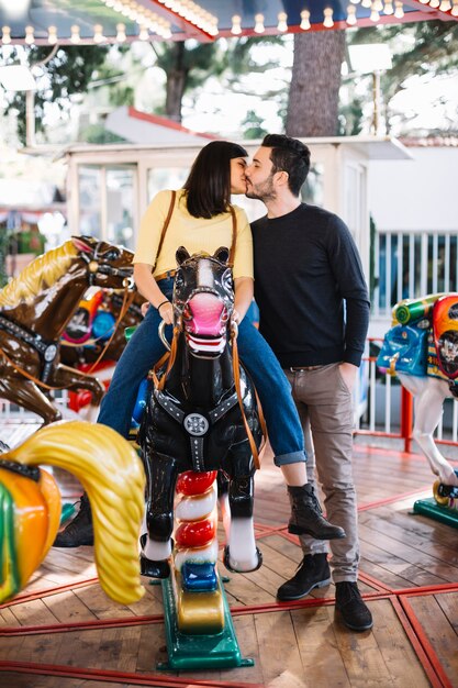 Girl kissing his boyfriend in the merry-go-round